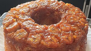 Een ronde cake met glazuur, geplaatst op een wit bord op een granieten aanrecht.