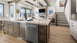 A modern kitchen with a large island, built-in appliances, and a stone fireplace. - Summit View Lodge, 5br5ba, Sleeps 16, HotTub-Views (Heber City)