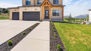 A modern two-story house with a stone facade, a garage, and a well-maintained lawn. - Summit View Lodge, 5br5ba, Sleeps 16, HotTub-Views (Heber City)