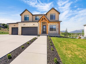 A modern two-story house with a stone facade, a garage, and a well-maintained lawn. - Summit View Lodge, 5br5ba, Sleeps 16, HotTub-Views (Heber City)