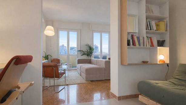 A modern living room with a sofa, a chair, a bookshelf, and a table. - Casa Matteo, panorama 20 min to Duomo (Milano)