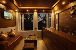 Un interior moderno con un banco de madera, una mesa de centro de cristal y una recepción de madera.