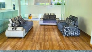 A modern living room with two sofas, a coffee table, and a glass partition. - Kommune Living (Gurugram)