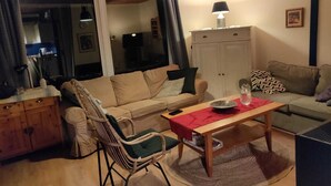 Ein gemütliches Wohnzimmer mit einer Couch, einem Sessel und einem Holztisch.