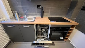 A compact kitchen with a built-in dishwasher, a sink, and a stove. - The Sixteen Suite, elegant apartment in University District, Milan. (Milano)