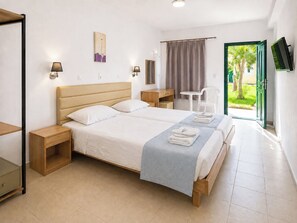 A hotel room with a double bed, bedside tables, a desk, a chair, a mirror, and a view of the outdoors. - Agnes Beach Hotel Apartments (Kavos)