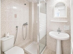 Habitación triple, en edificio anexo | Baño | Ducha, secador de pelo, toallas y papel higiénico