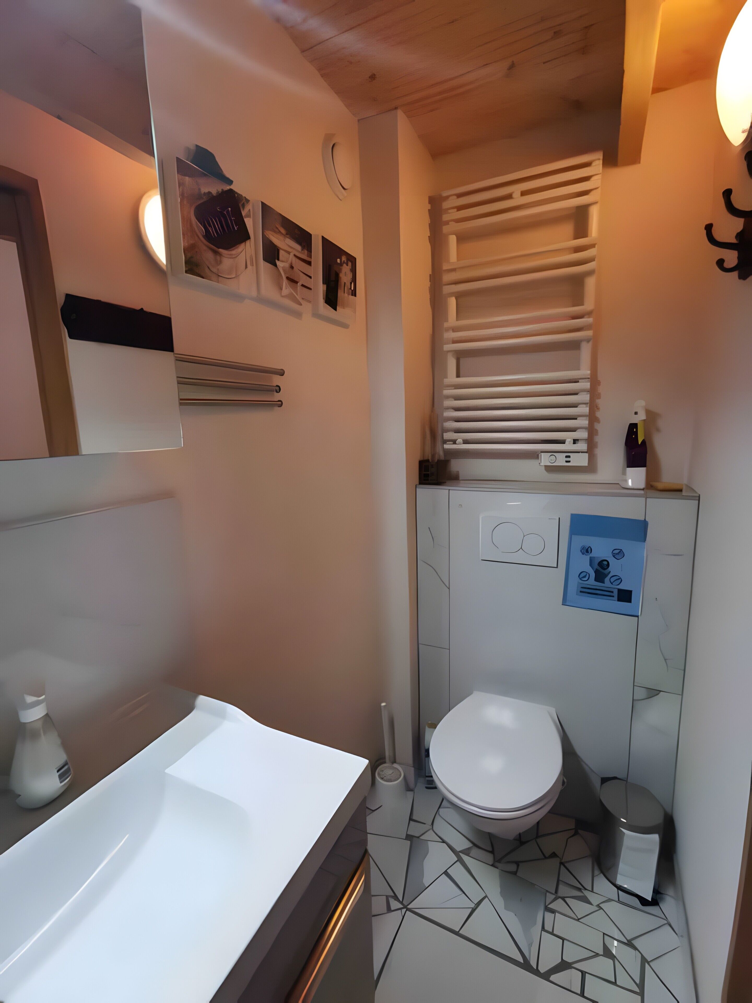 A bathroom with a white sink, a toilet, a towel rack, and a mirror.