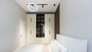 Un dormitorio con cama, armario y espejo.