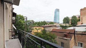 Un balcón con vistas a un edificio moderno y edificios residenciales circundantes.