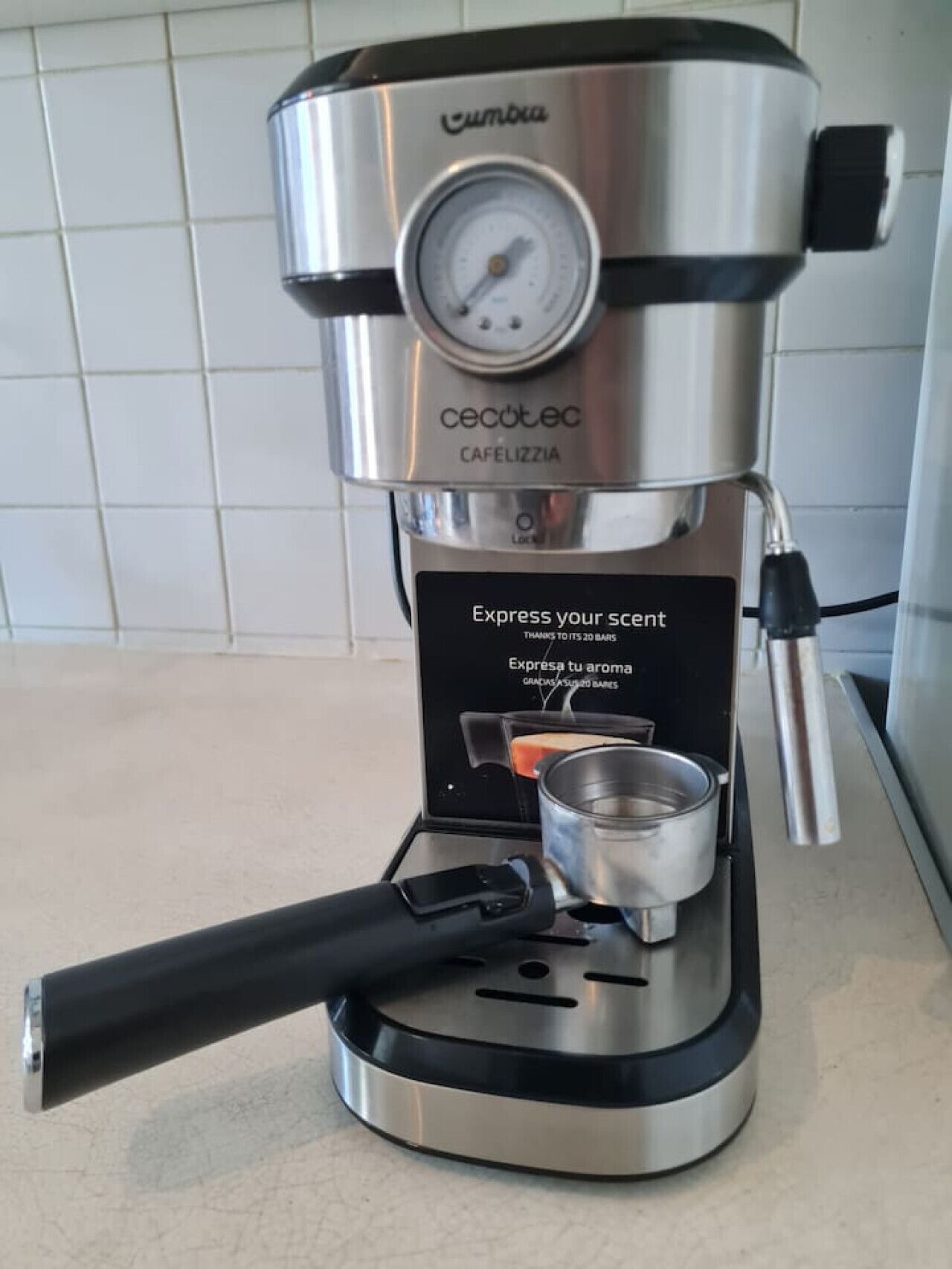 A compact, modern coffee maker with a digital pressure gauge, a small cup holder, and a sleek design.