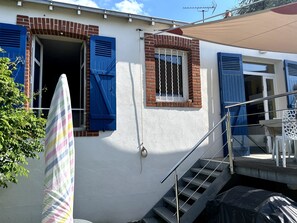 A residential building with blue shutters, a staircase, and a covered outdoor area. - Fisherman’s House with Private Garden – Comfort & Privacy in Pornic (Pornic)