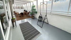 A balcony with a seating area, a hanging plant, and a metal rack. - Modern and Stylish apartment in downtown Reykjavik - Great location ! (Reykjavik)