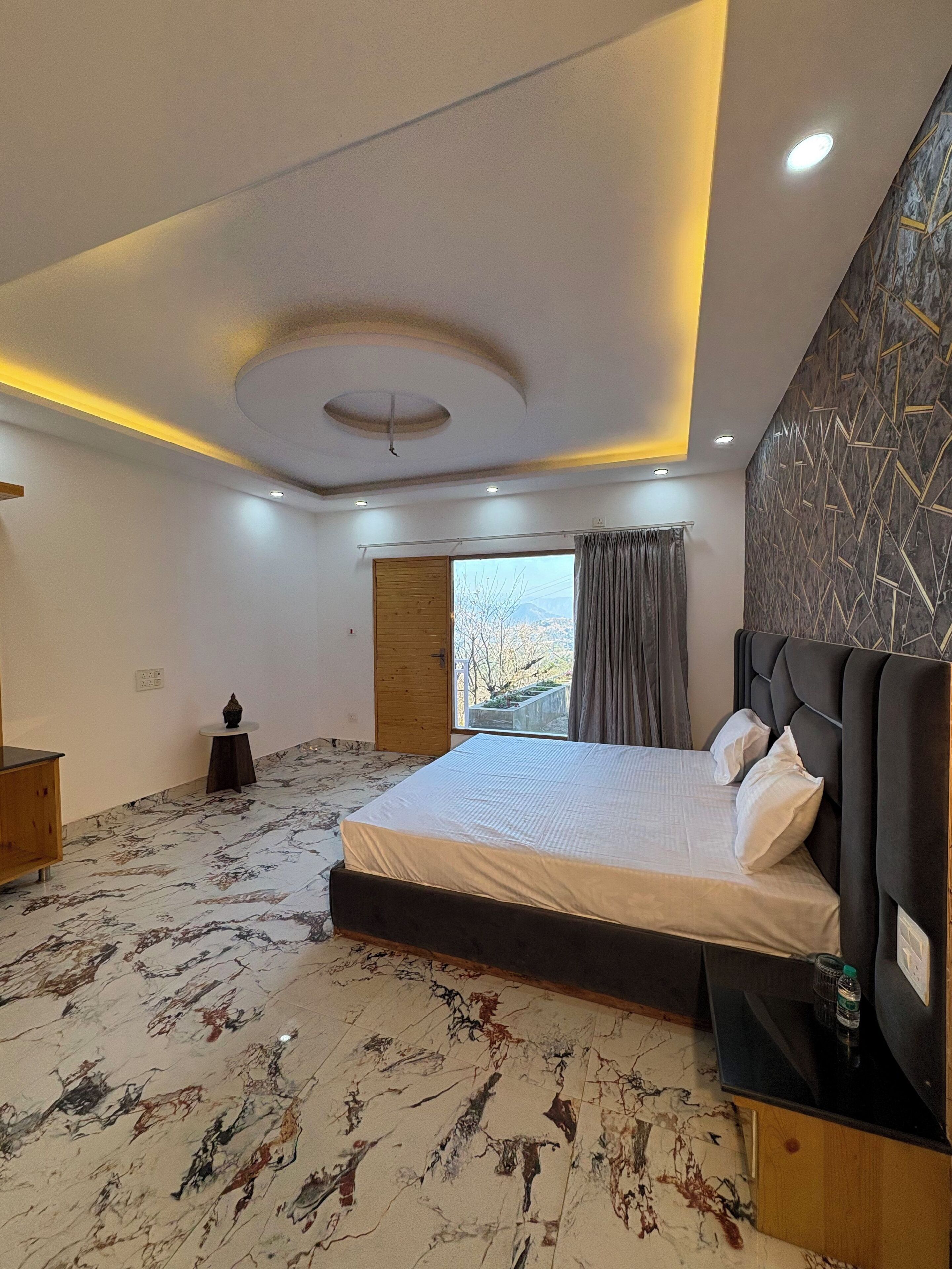 Een moderne slaapkamer met een groot bed, een houten hoofdeinde, een vloer met een marmerpatroon en uitzicht op het landschap door een raam.