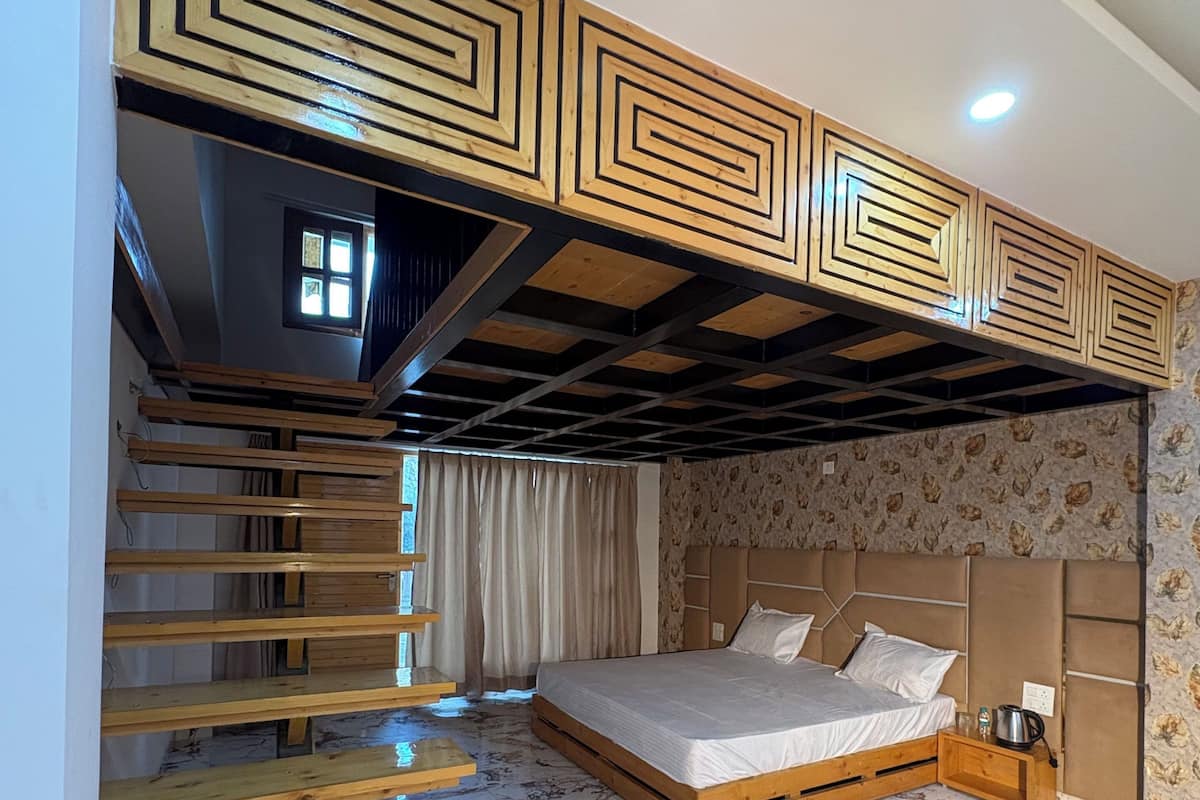 A bedroom with a bed, a wooden staircase, and a patterned wall.