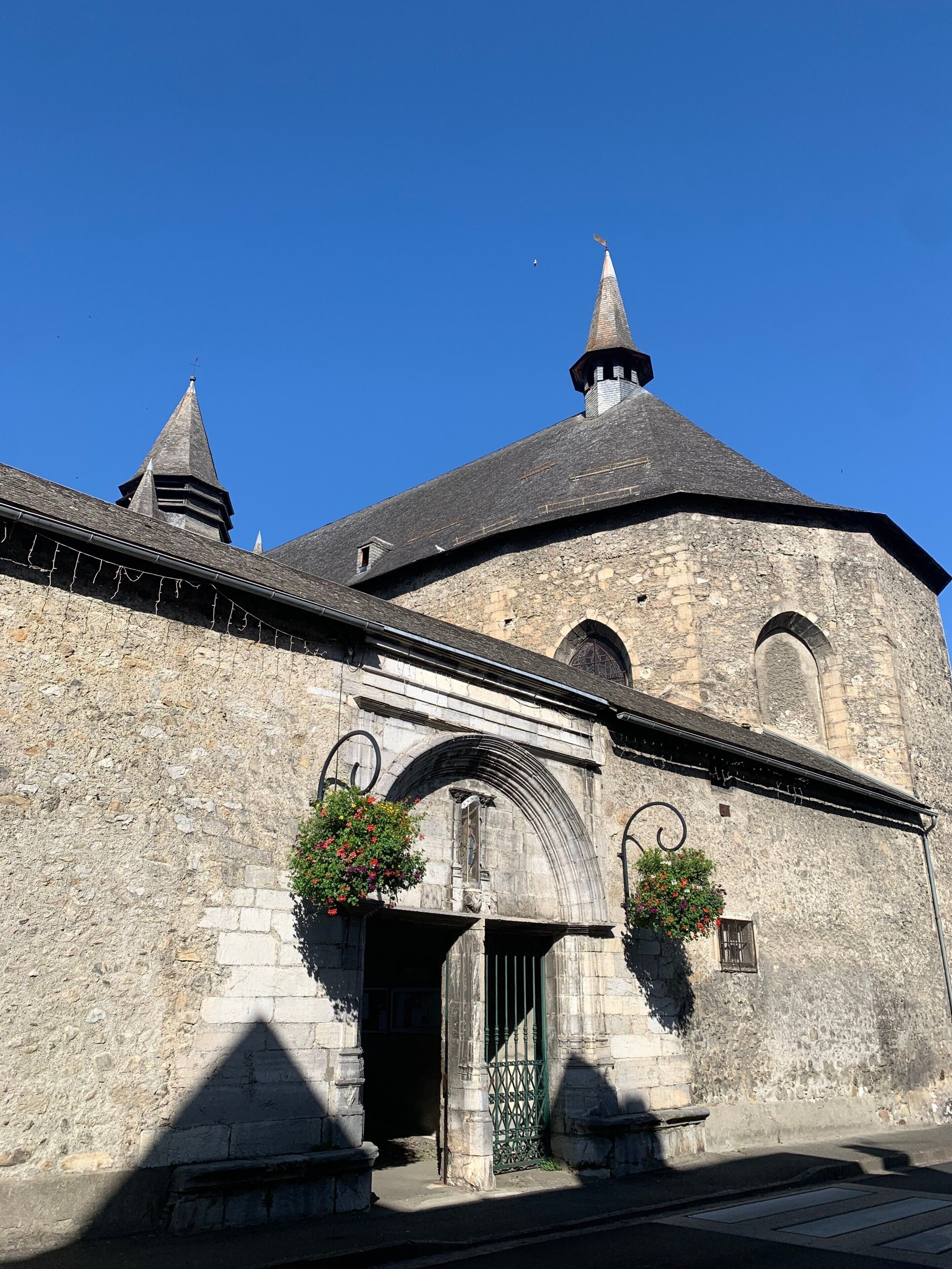 Un edificio storico in pietra con un tetto a punta e un campanile.