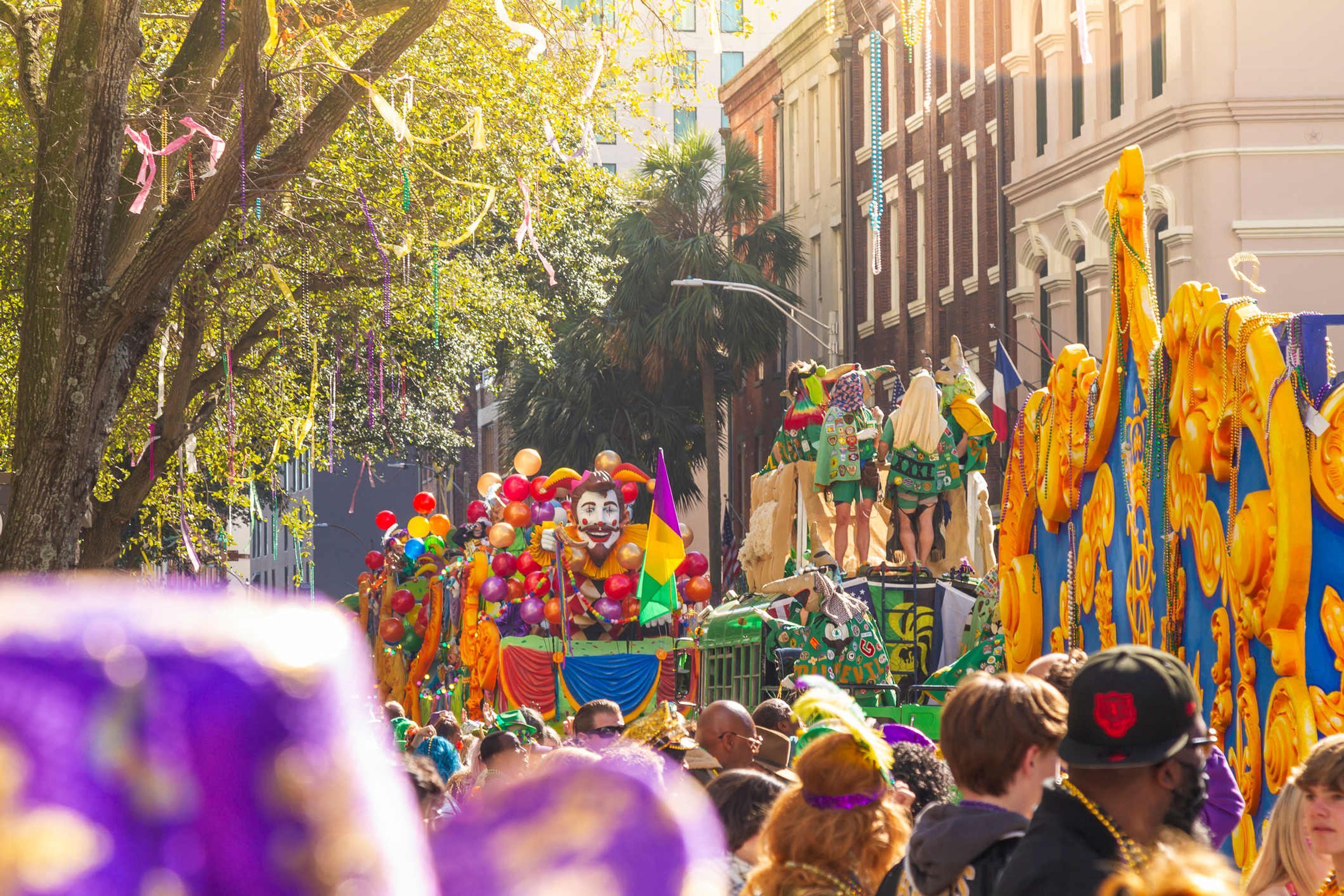 Un desfile con carrozas coloridas y participantes.