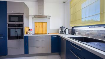 Een koelkast, een waterkoker, kookgerei, borden en bestek, kruiden