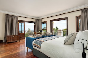 A hotel room with a large bed, a sofa, a wooden dresser, and a balcony with a view. - Disandt House by Neighbourgood (Cape Town)