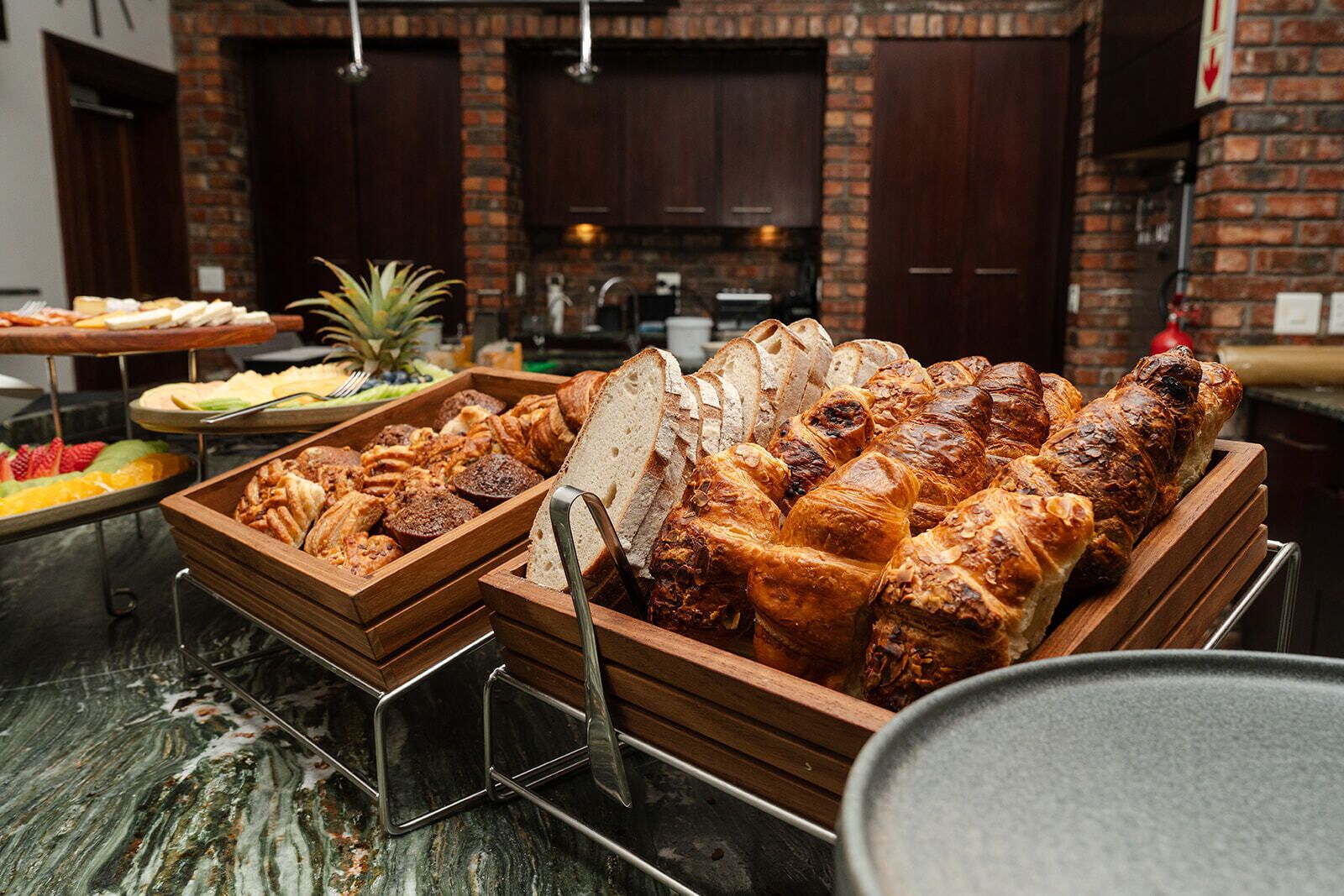 A buffet with various breads and pastries.
