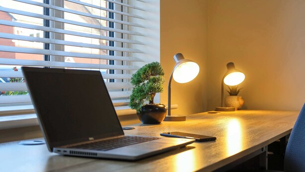 A laptop on a wooden desk with a potted plant and two desk lamps. - Spacious 5-bed Contractor House - Parking Wi-fi (Coventry)