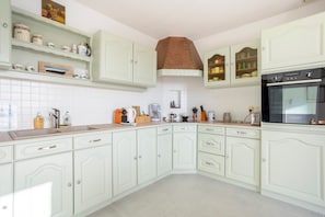 A kitchen with white cabinets, a built-in oven, and a coffee maker. - Windows to the Infinite Blue – Sea View & Direct Beach Access (Concarneau)