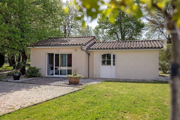 Un petit bâtiment avec un toit en tuiles, une porte et une fenêtre.