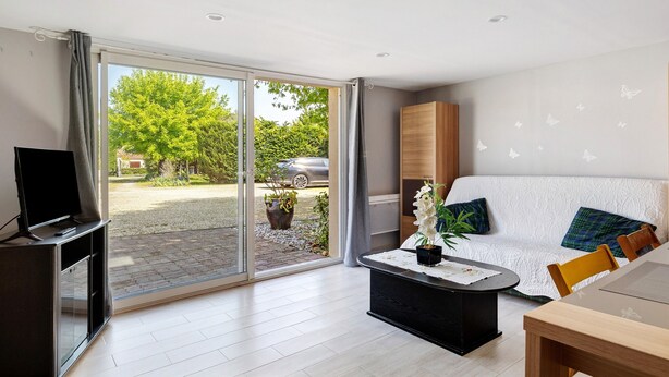 A modern living room with a sofa, coffee table, and TV stand.