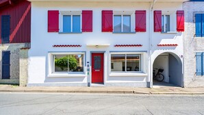 A two-story building with a red door, multiple windows with shutters, and a bicycle parked outside. - Bed and Breakfast 'Callune' with Wi-Fi and Air Conditioning (Capbreton)