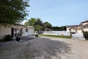 A courtyard with a gravel path, potted plants, and a building with a tiled roof. - Bed and Breakfast 'Chambre D'hôtes Myosotis' with Shared Pool, Shared Terrace and Wi-Fi (Bégadan)
