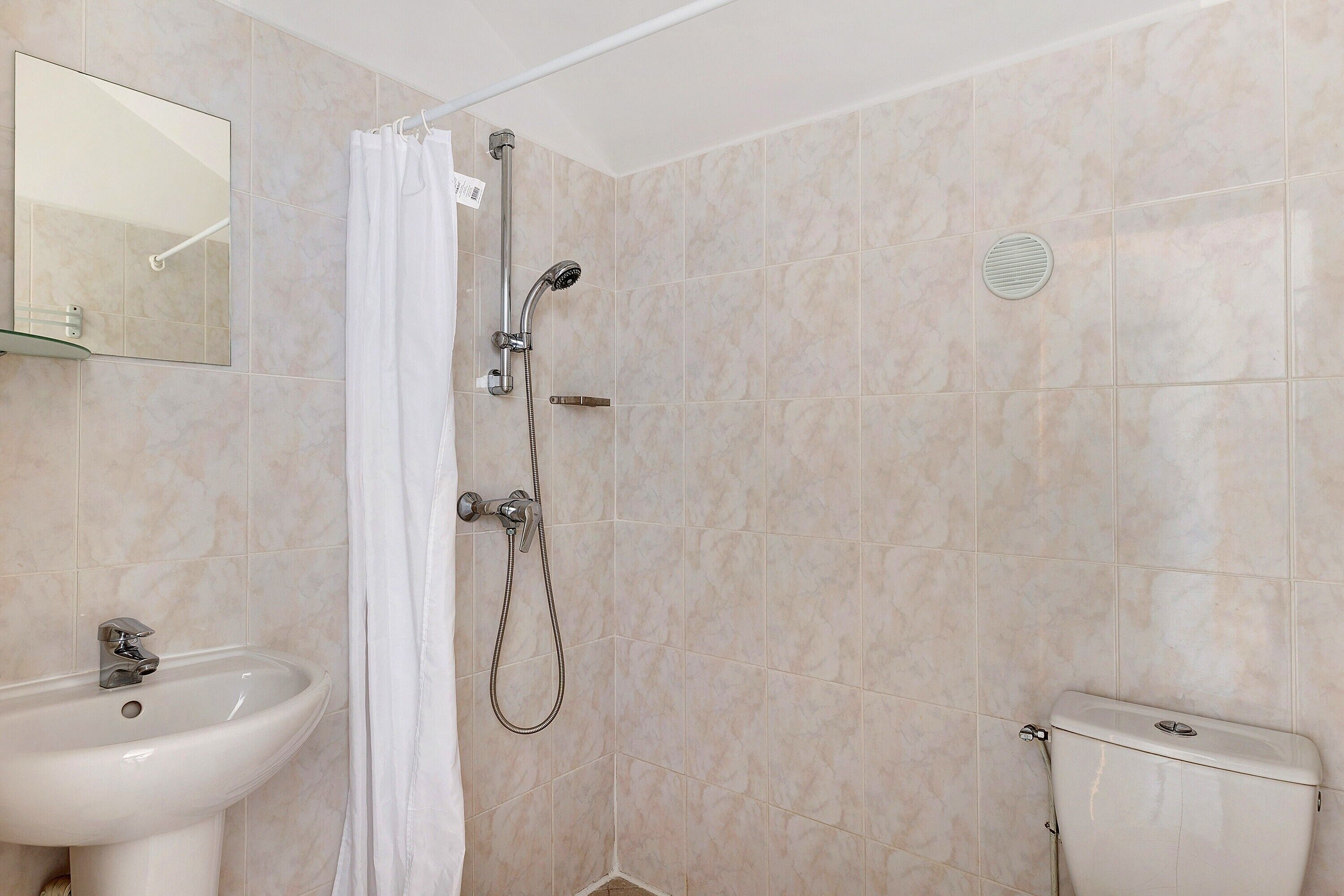 Ein Badezimmer mit Dusche, Waschbecken und Toilette.