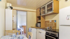 Une cuisine compacte équipée d’un lave-linge, d’un four à micro-ondes, d’une cuisinière et d’un réfrigérateur.