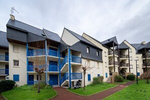 A multi-story residential building with balconies, a central staircase, and a small garden area. - Sailing, port, near beach & Thalasso, parking, towels & cleaning not included (Arzon)