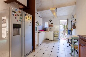 A kitchen with a refrigerator, microwave, stove, and sink. - Apartment “Gîte Entre Mer Et Jardin Ei Riazi” with Sea View, Wi-Fi, and Air Conditioning (Sausset-les-Pins)