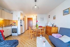 Ein gemütlicher Wohnbereich mit Küchenzeile, Essbereich und einer Couch.