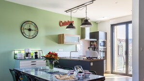 Et moderne køkken med spiseplads, et ur og et skilt med teksten 'Cuisine'.