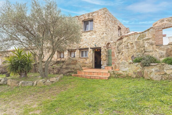 A stone building with a small porch, a window, and a door.