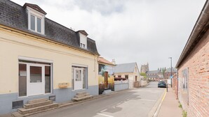 Eine Straße mit Gebäuden, einem Auto und einer Kirche im Hintergrund.