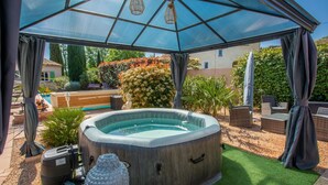 A hot tub under a transparent canopy with a pool and garden in the background. - Guest Room "Chrisama" with Shared Pool, Wi-Fi, and Air Conditioning (Flayosc)