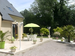 A house with a patio, outdoor furniture, and potted plants. - Bed and Breakfast 'Chez Mireille - Chambre Maya' with Shared Garden, Balcony and Wi-Fi (Cancale)