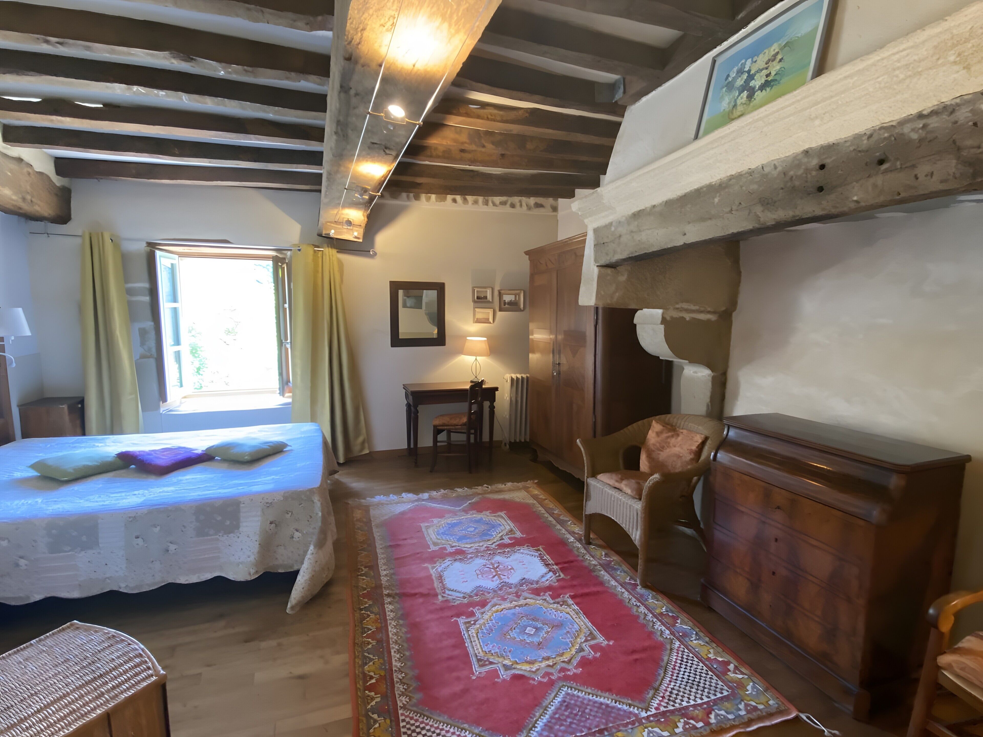 A room with a bed, a desk, a chair, a cabinet, and a patterned rug.