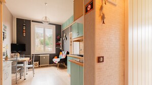 Een keuken met een eethoek, een radiator en een raam.