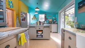 Una cocina con una isla central, un refrigerador y un microondas.