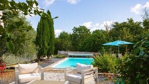 A pool area with a wooden deck, white outdoor furniture, and a blue umbrella. - Guest Rooms - Aubépine and Bleuet Rooms (Courçon)