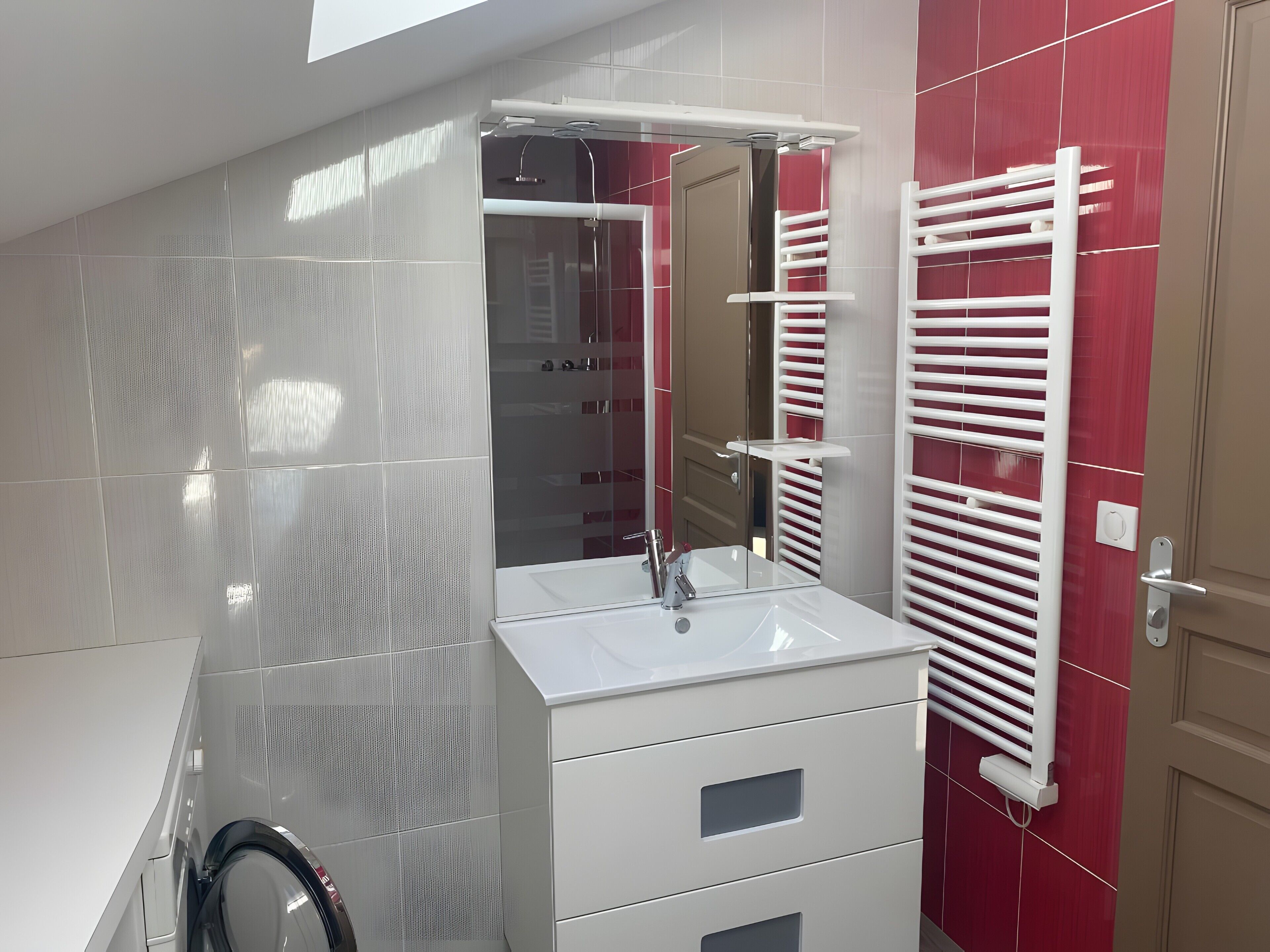 Ein modernes Badezimmer mit Duschkabine aus Glas, einem weißen Waschbecken und einem Handtuchhalter.