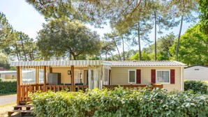 A mobile home with a porch, a dining area, and a small kitchen. - Mobile Home 'Mh324 La Tremblade' with Shared Pool, Private Terrace, and Air Conditioning (La Tremblade)