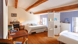Ein Schlafzimmer mit einem Bett, Holzmöbeln, einem Schreibtisch und einem Regal.