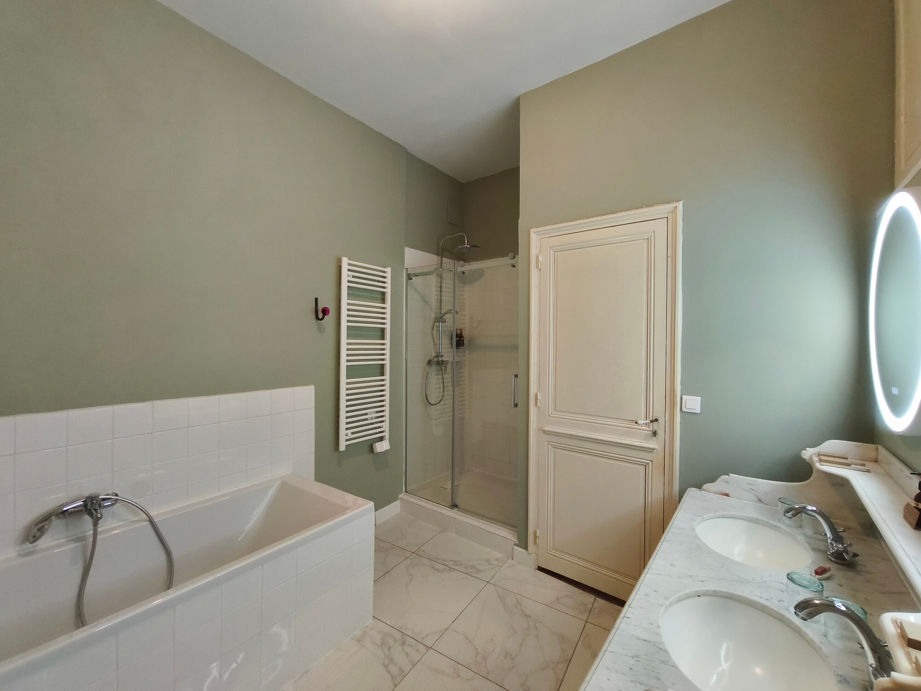 A bathroom with a bathtub, a shower, and a vanity with two sinks.