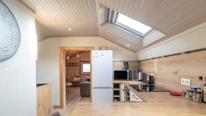 Una cocina moderna con microondas, estufa y armarios de madera.