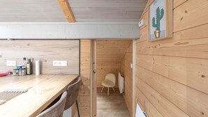Un interior de madera con una mesa, sillas, un enchufe y una decoración de cactus.